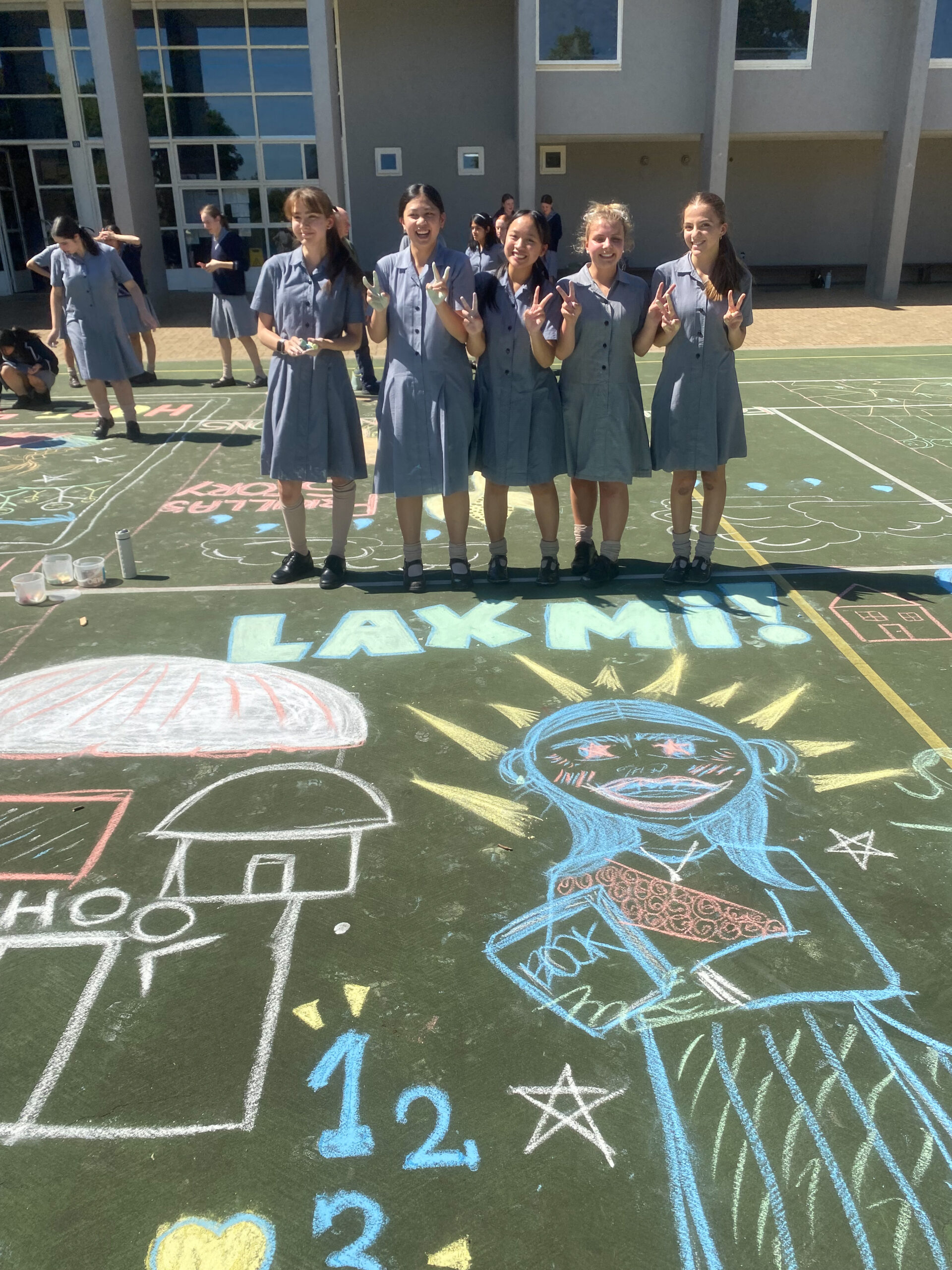 Children standing before their chalk artwork